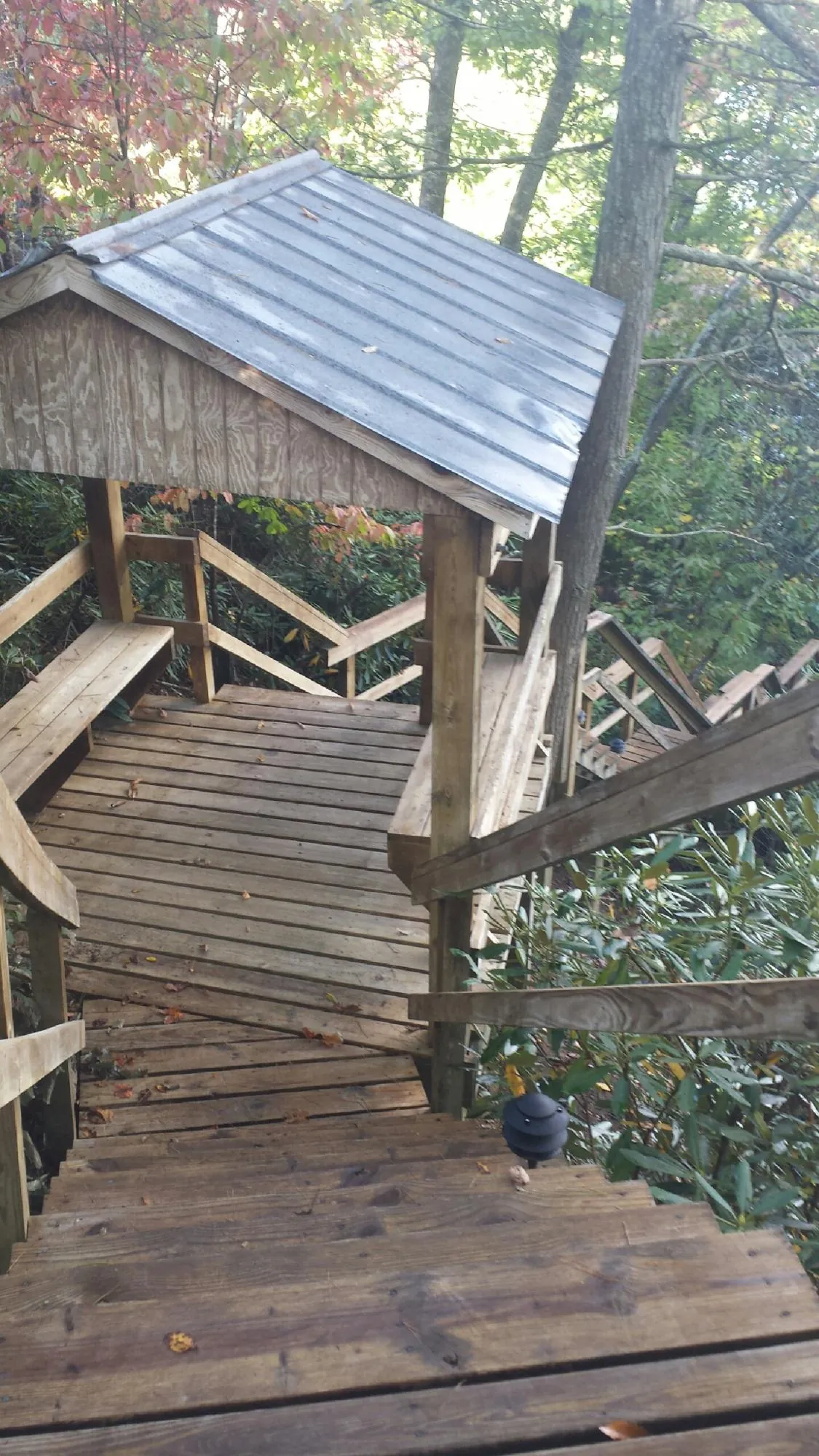 Metal roofed shelter over wooden steps on a wooded walkway — Skylight Repair & Installation work by our crew in Long Island City