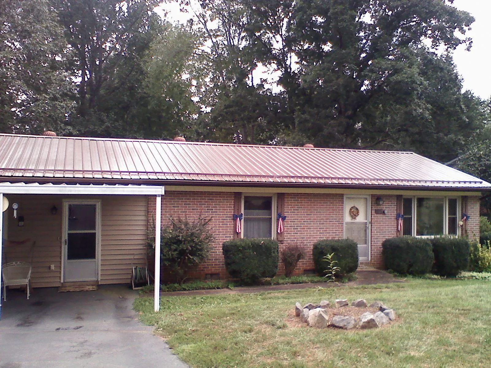 Bronze metal roof and carport on a brick ranch home — Roof Repair work by our crew in Long Island City